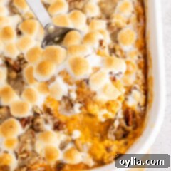 Close up photo of a spoonful of Sweet Potato Casserole in the casserole dish
