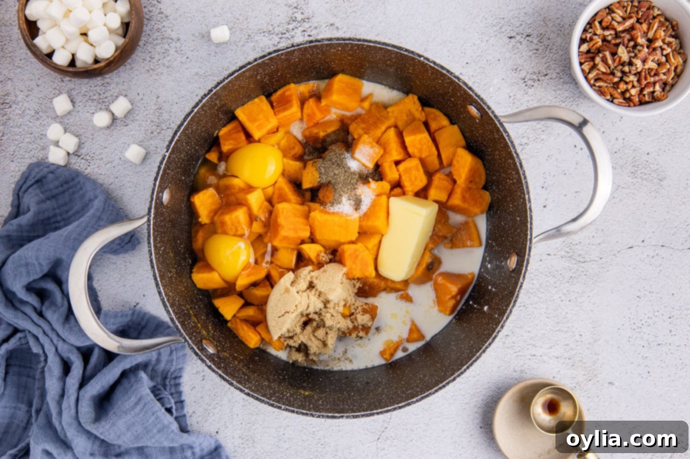 cubed sweet potatoes in a pot with butter, brown sugar, egg, and spices