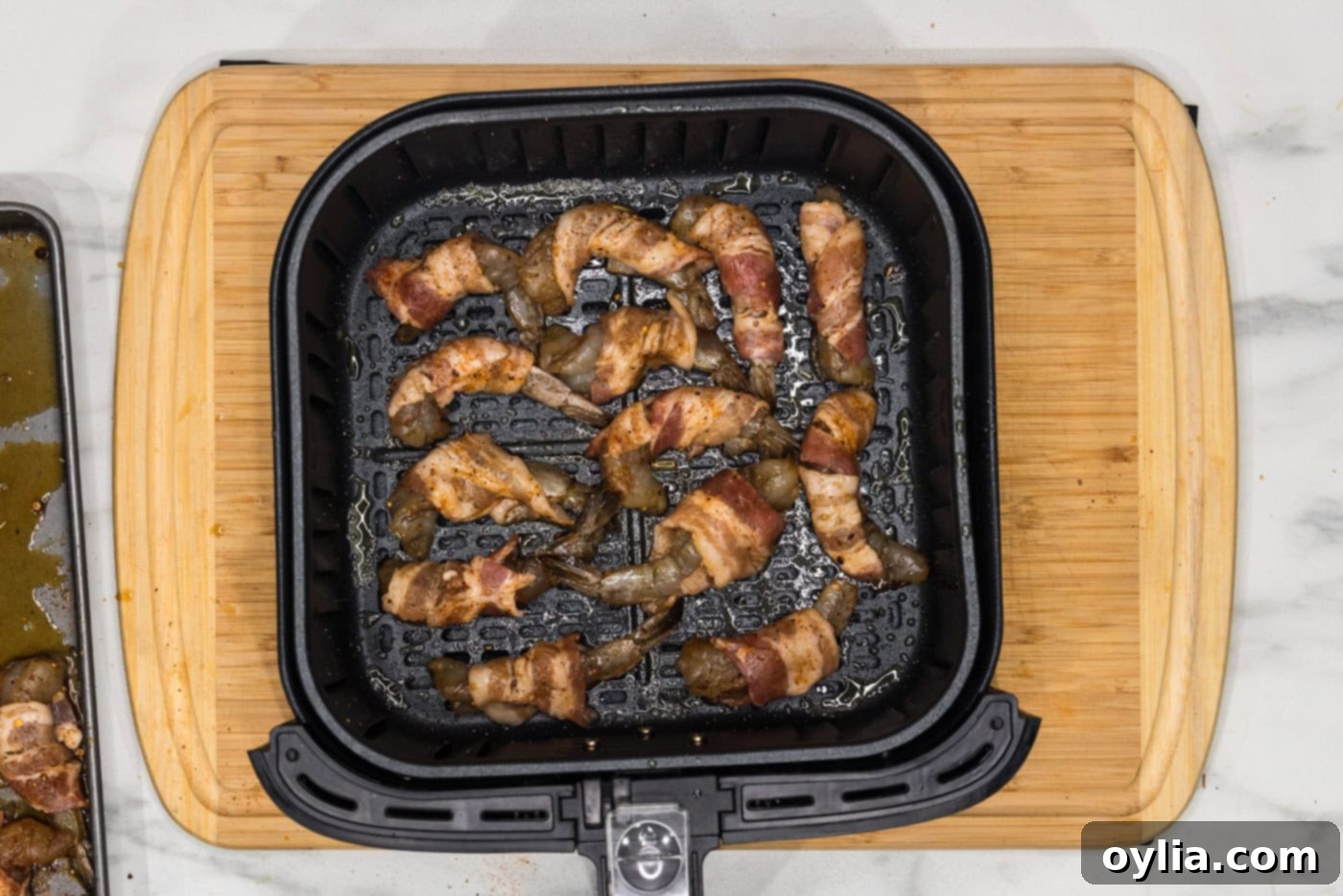 bacon wrapped shrimp in an air fryer basket