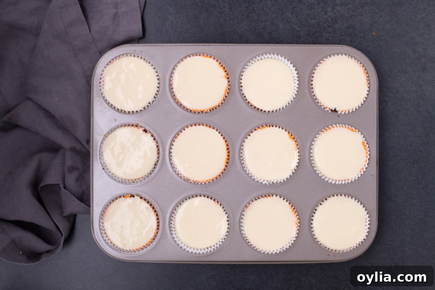 Vanilla (white) cheesecake batter as the top layer in a cupcake pan, completing the candy corn colors