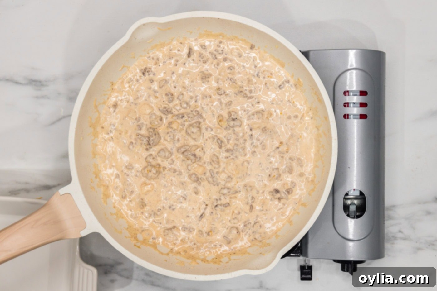 The fully combined cheeseburger dip mixture, rich and ready for baking, in the skillet.