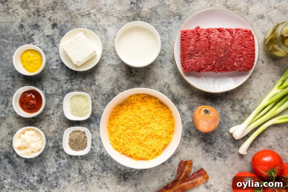A spread of fresh ingredients laid out, including ground beef, cream cheese, heavy cream, shredded cheddar, olive oil, garlic salt, pepper, and chopped onions.
