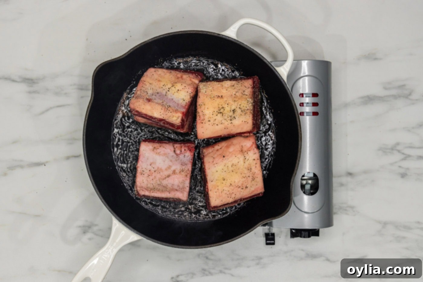 short ribs searing in a skillet