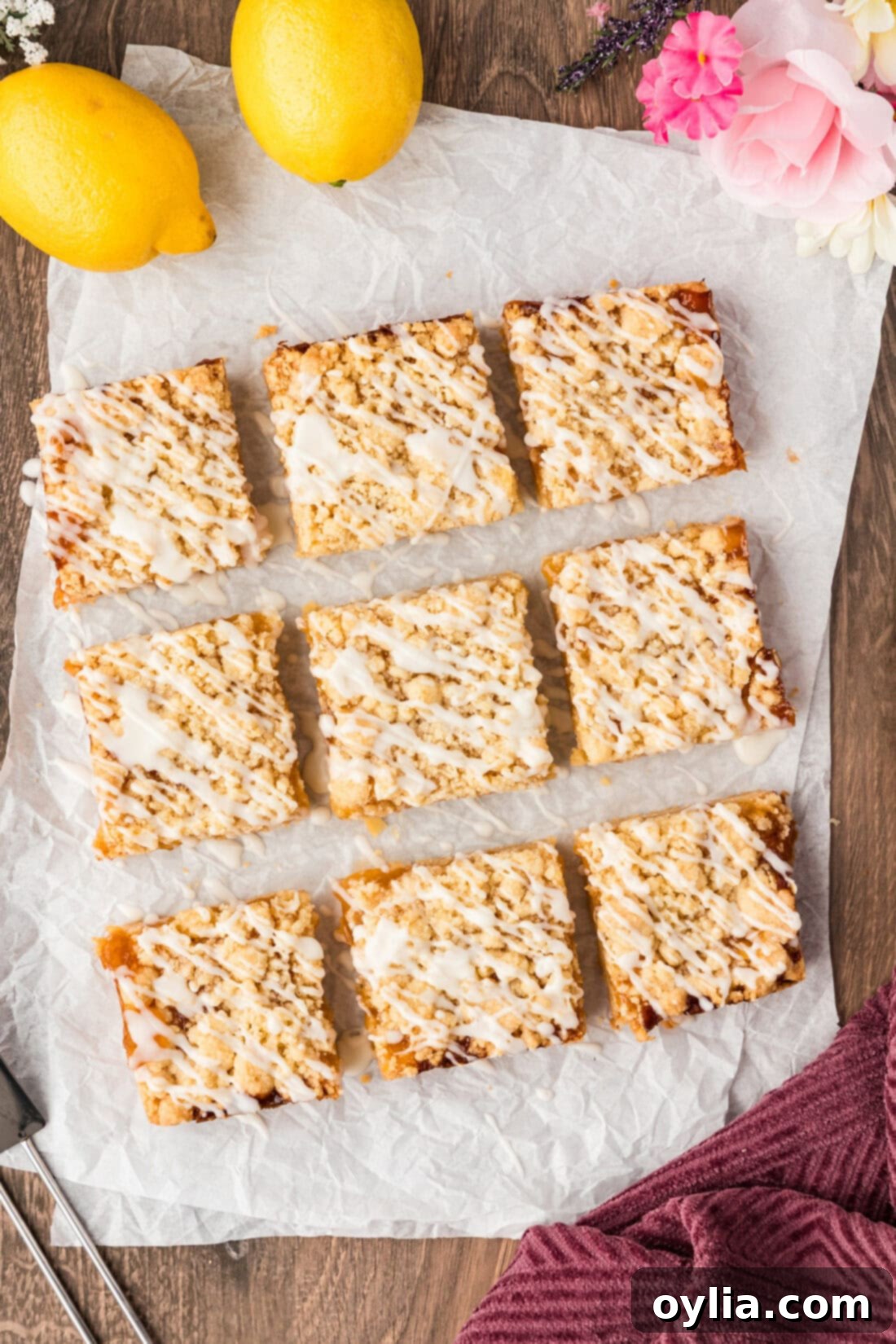 Lemon Streusel Squares beautifully cut into nine perfect squares and resting on parchment paper, ready to be picked up and enjoyed.