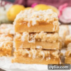 Close up photo of a stack of Lemon Streusel Squares, showing the distinct layers of shortbread, lemon curd, and streusel topping.