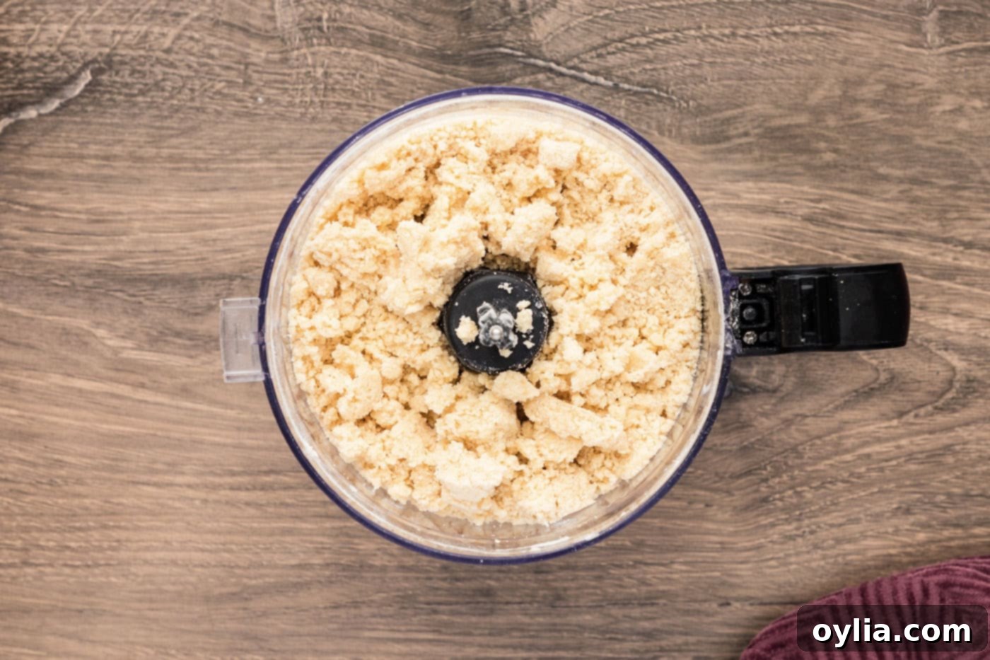 Close-up of the perfectly crumbly shortbread mixture in the food processor, ideal for the base and streusel topping of the lemon bars.
