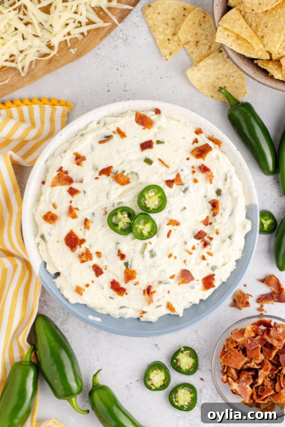Bowl of Crockpot Jalapeno Popper Dip topped with sliced jalapeno and bacon pieces 