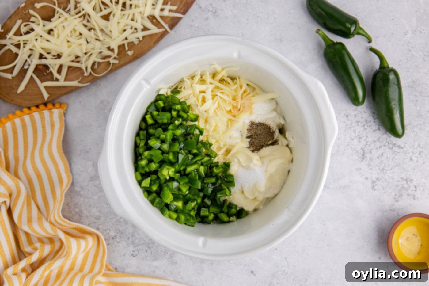 chopped jalapenos, mayo, sour cream, shredded cheese, and cream cheese in a slow cooker crock