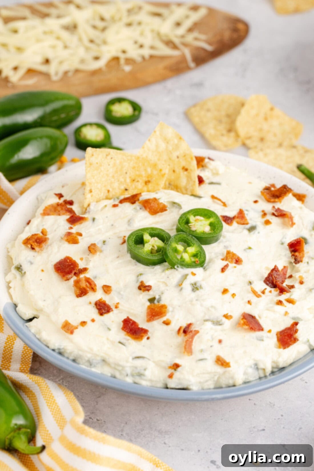 Close up photo of a bowl of Crockpot Jalapeno Popper Dip with two chips stuck in it