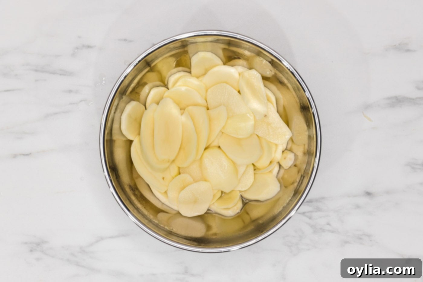 Creamy Slow Cooker Scalloped Potatoes 5 thinly sliced potatoes in a bowl