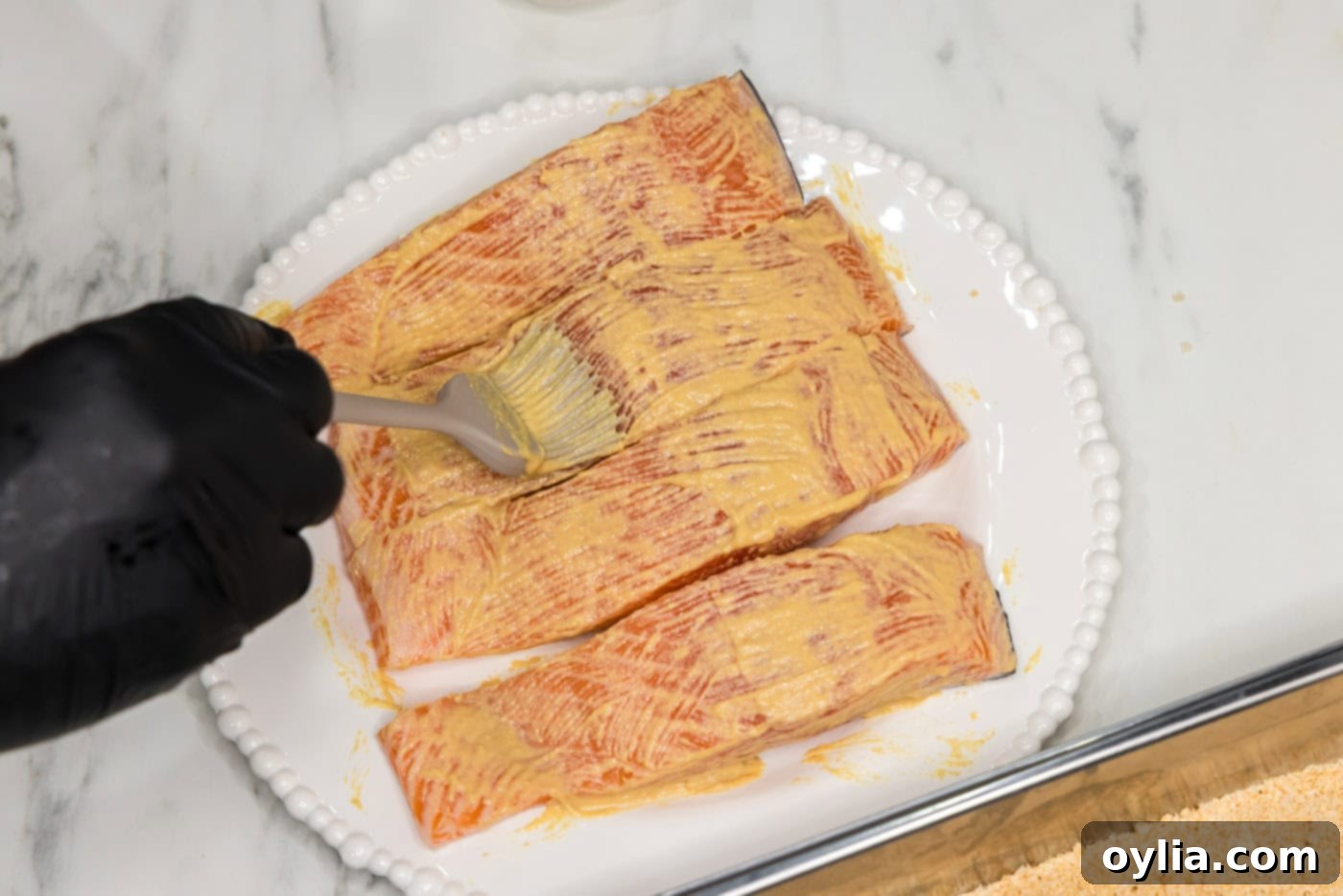 brushing salmon filets with dijon mustard