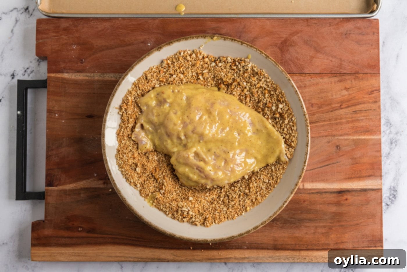 coating honey mustard chicken in crushed pretzels, creating the crispy crust
