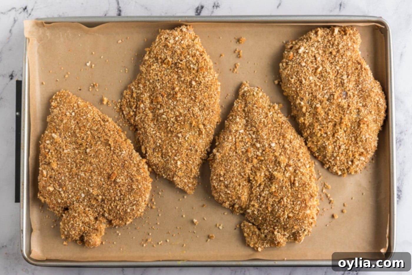 pretzel coated chicken breasts on a baking sheet, golden and ready after baking