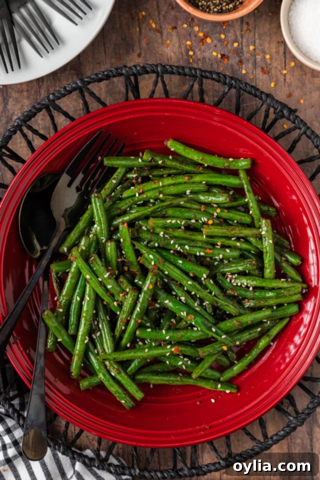 Vibrant Green Bean Sauté 2 Sautéed Green Beans on a red plate with a serving fork and spoon resting to the side