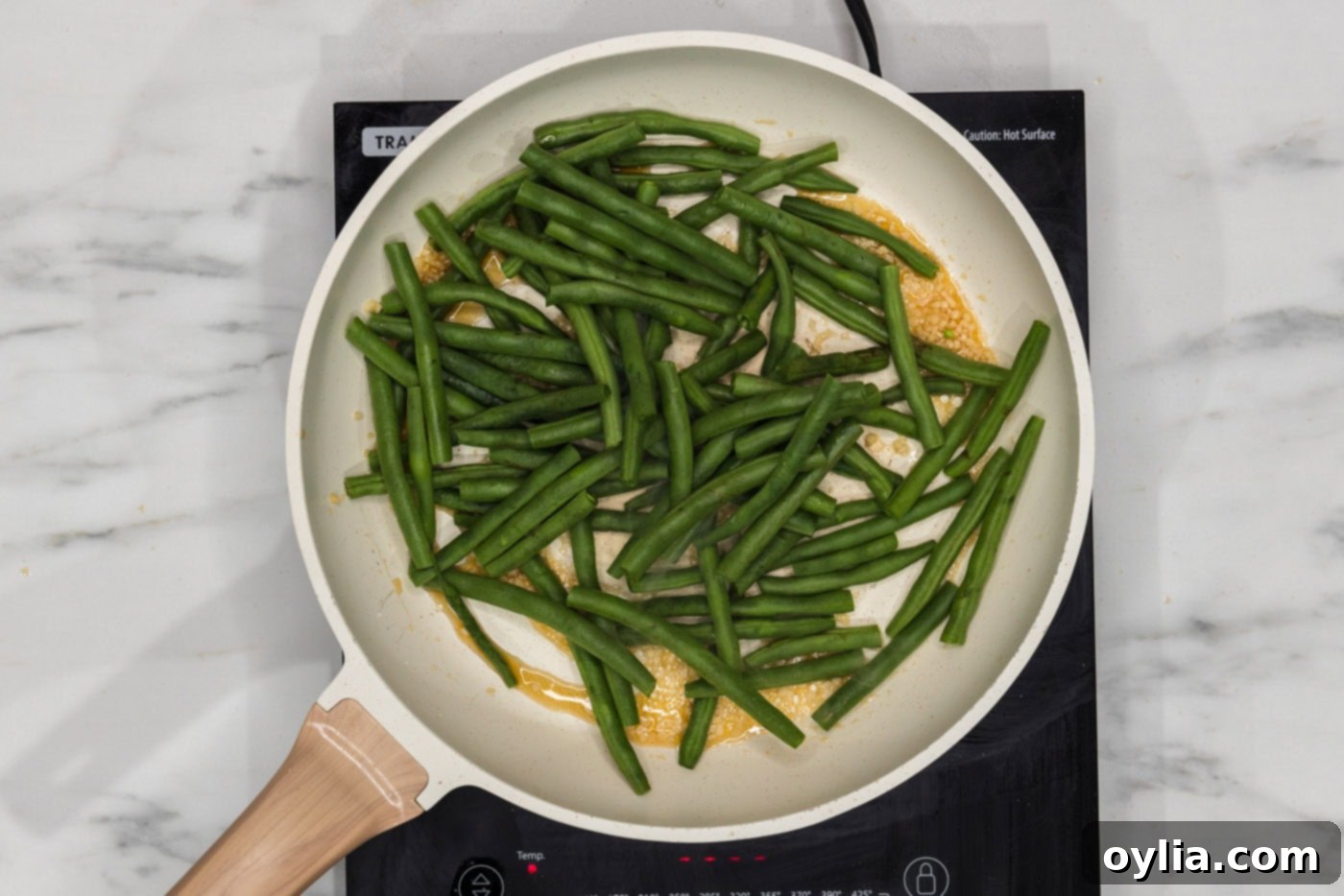 green beans in a skillet with garlic and sesame oil