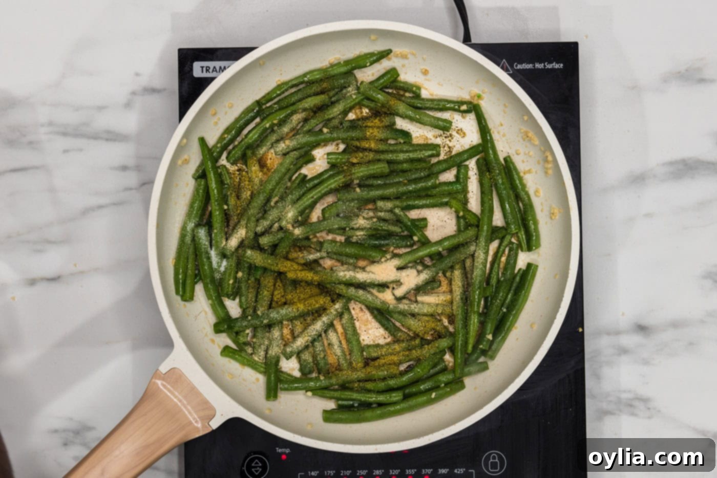 green beans in a skillet with sesame oil and seasonings
