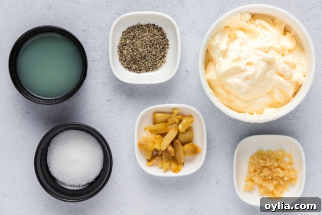 Homemade Garlic Aioli 4 A visual display of all the fresh ingredients required for making Homemade Garlic Aioli, including a whole head of garlic, bright yellow lemons, a jar of mayonnaise, and a sprinkling of salt and pepper.