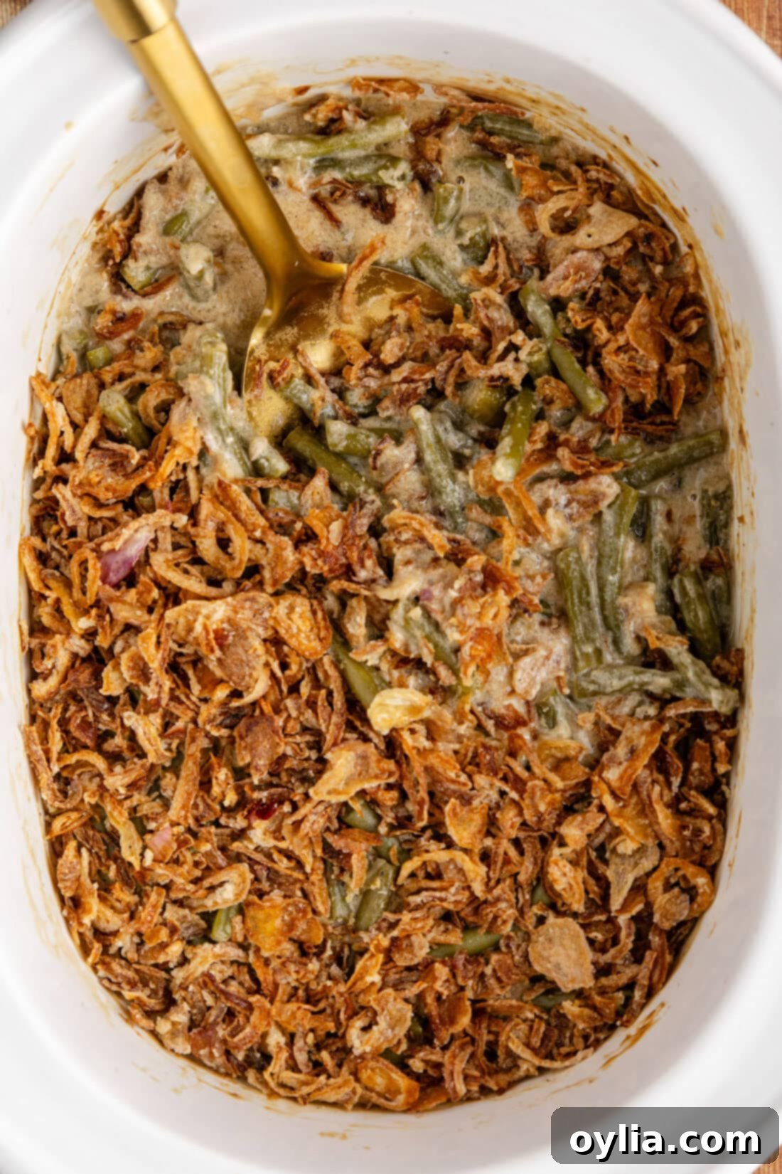Close up photo of the comforting Crockpot Green Bean Casserole simmering in a slow cooker