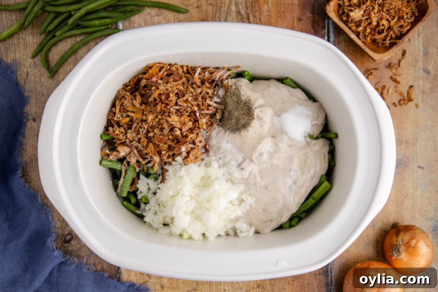 All green bean casserole ingredients freshly added to a crockpot before mixing