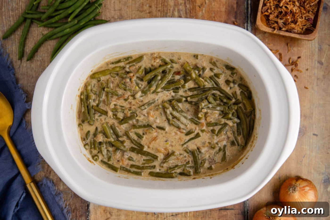 Finished Crockpot Green Bean Casserole, perfectly cooked and topped with crispy fried onions, ready to be served