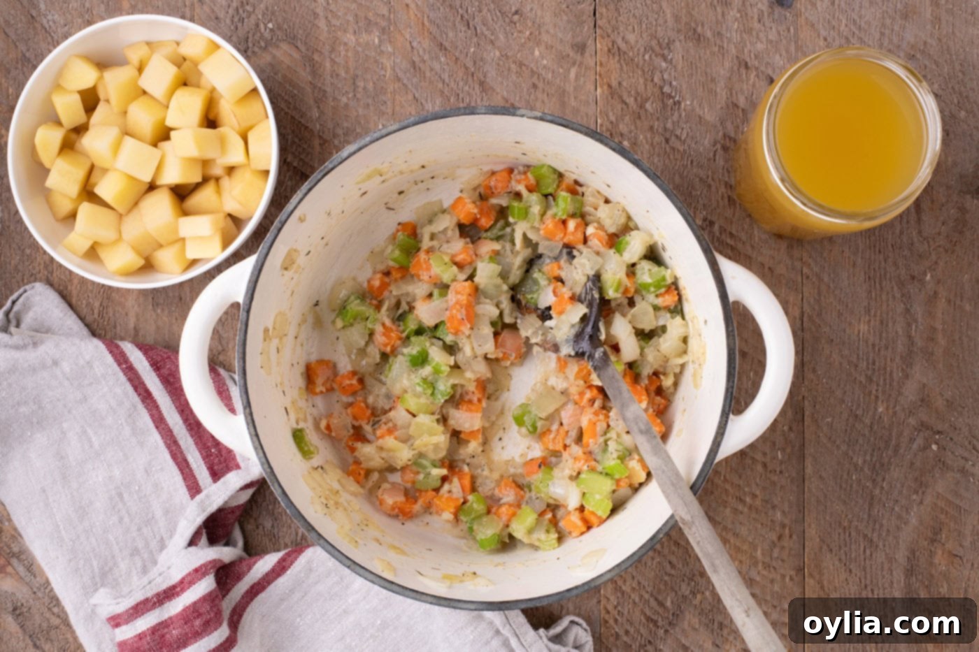 Mixing flour into the sautéed vegetables in a Dutch oven to create a roux, thickening the soup base.