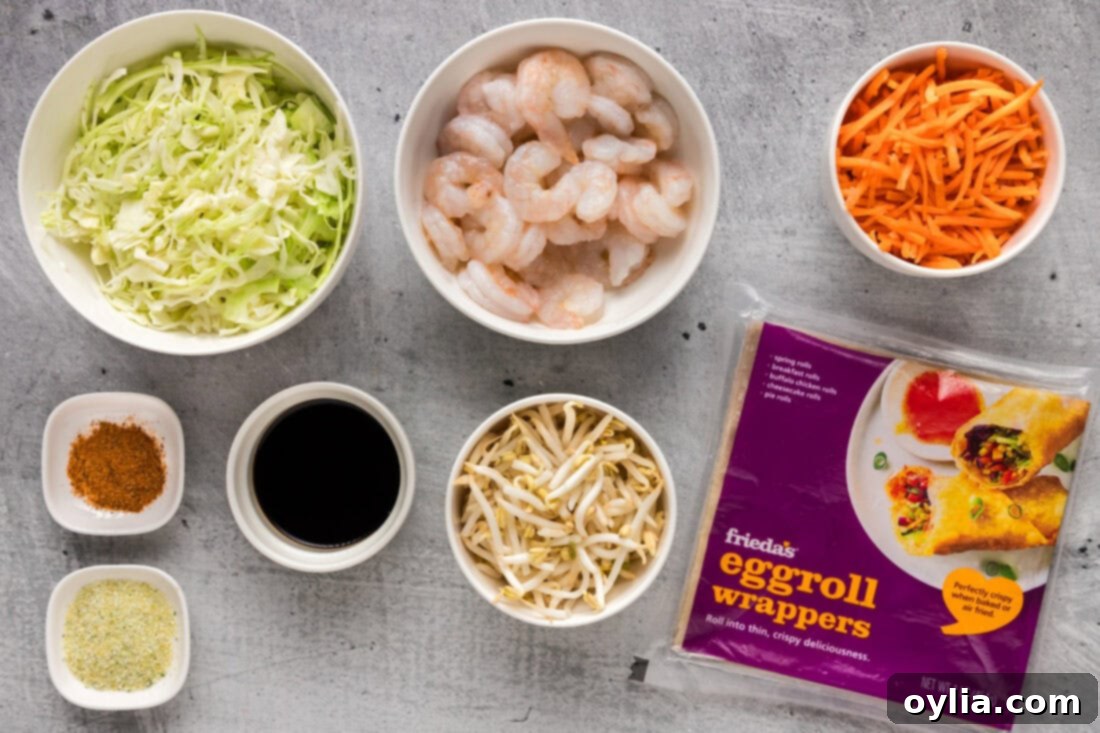 A vibrant selection of fresh ingredients including small raw shrimp, shredded cabbage, carrots, bean sprouts, garlic salt, Old Bay, and soy sauce, laid out for shrimp egg rolls preparation