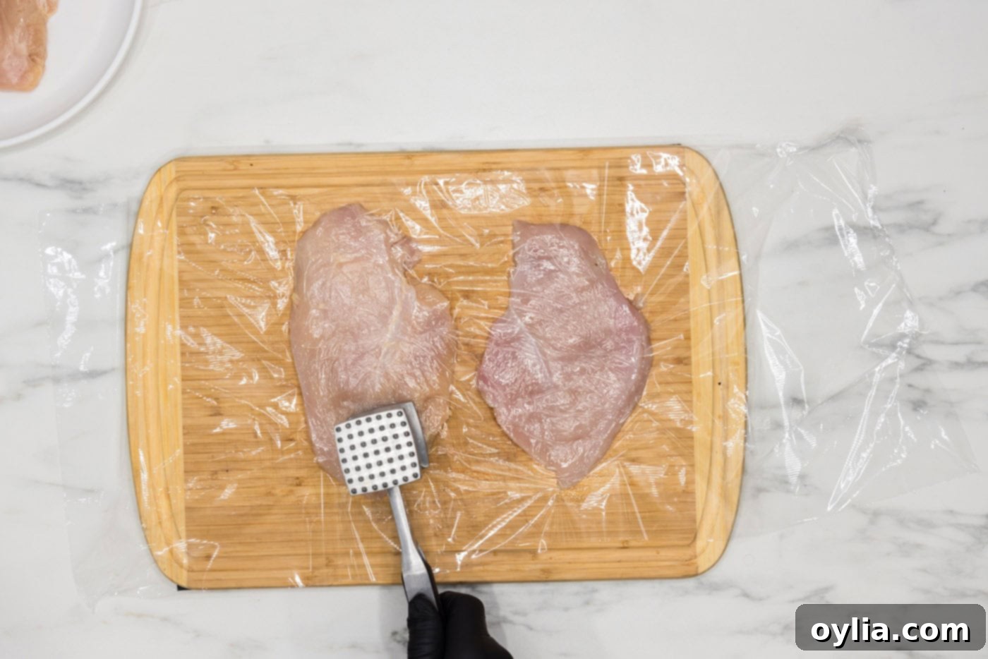 pounding chicken breast with a meat mallet