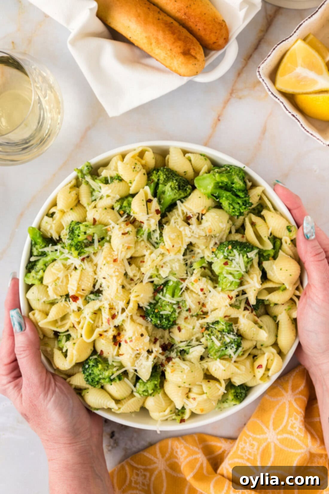 Hands holding a bowl of Broccoli Pasta