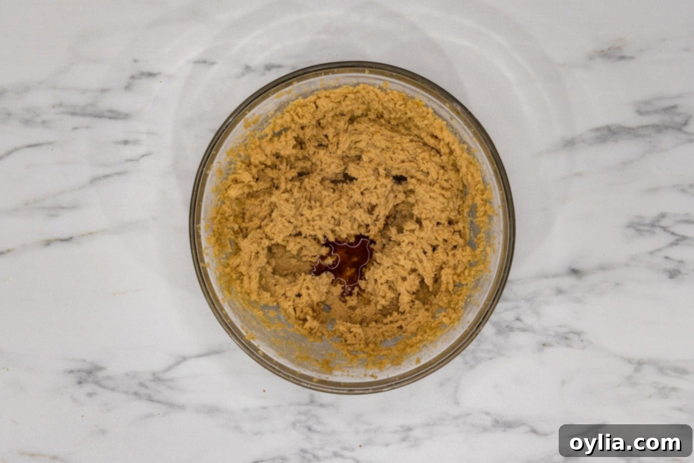 Creamed butter and sugar mixture in a bowl of an electric mixer, looking light and fluffy.