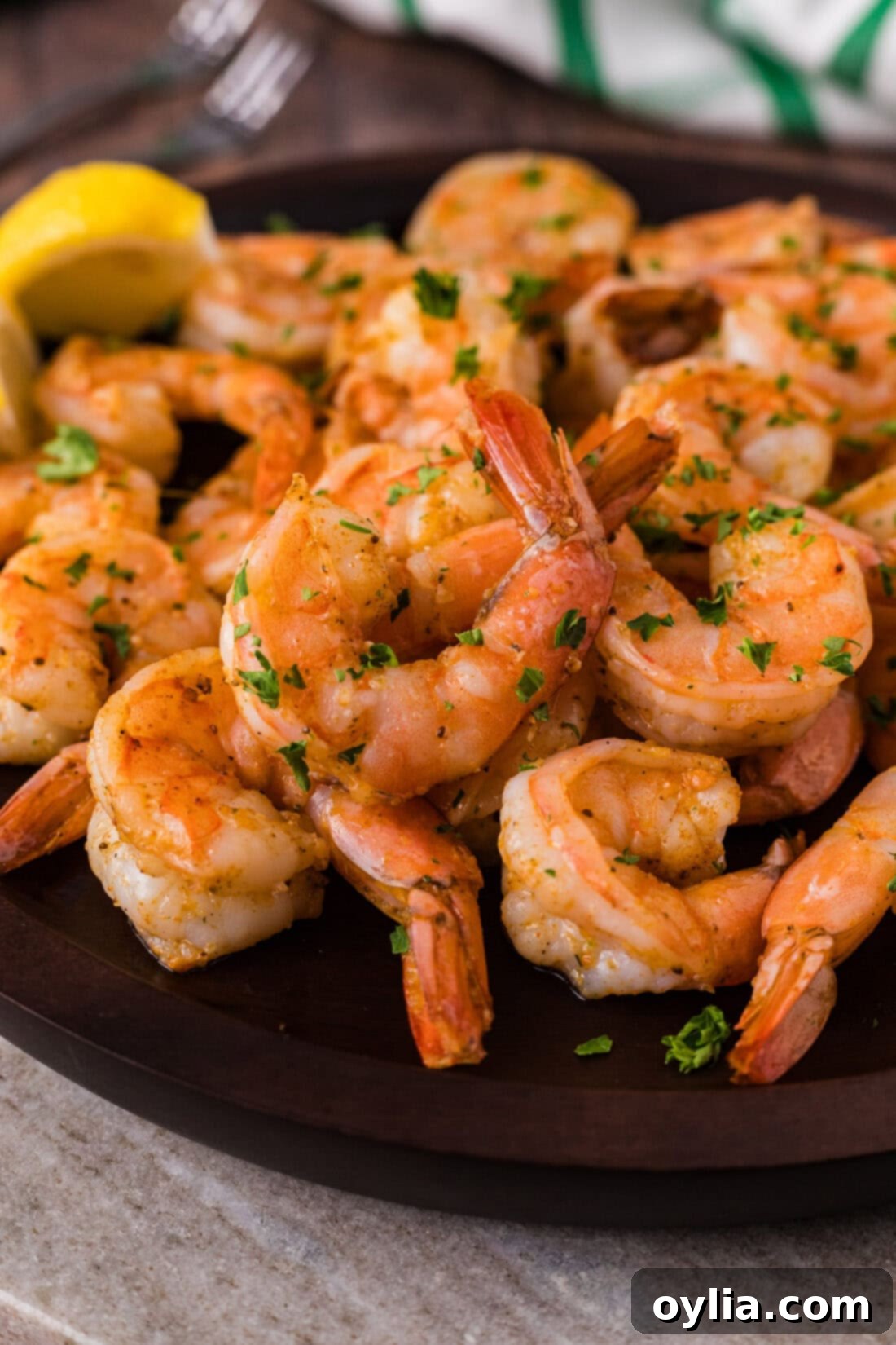 Succulent Steamed Shrimp 2 Close up photo of perfectly steamed shrimp piled on a plate, garnished with fresh herbs and lemon wedges, ready to be served