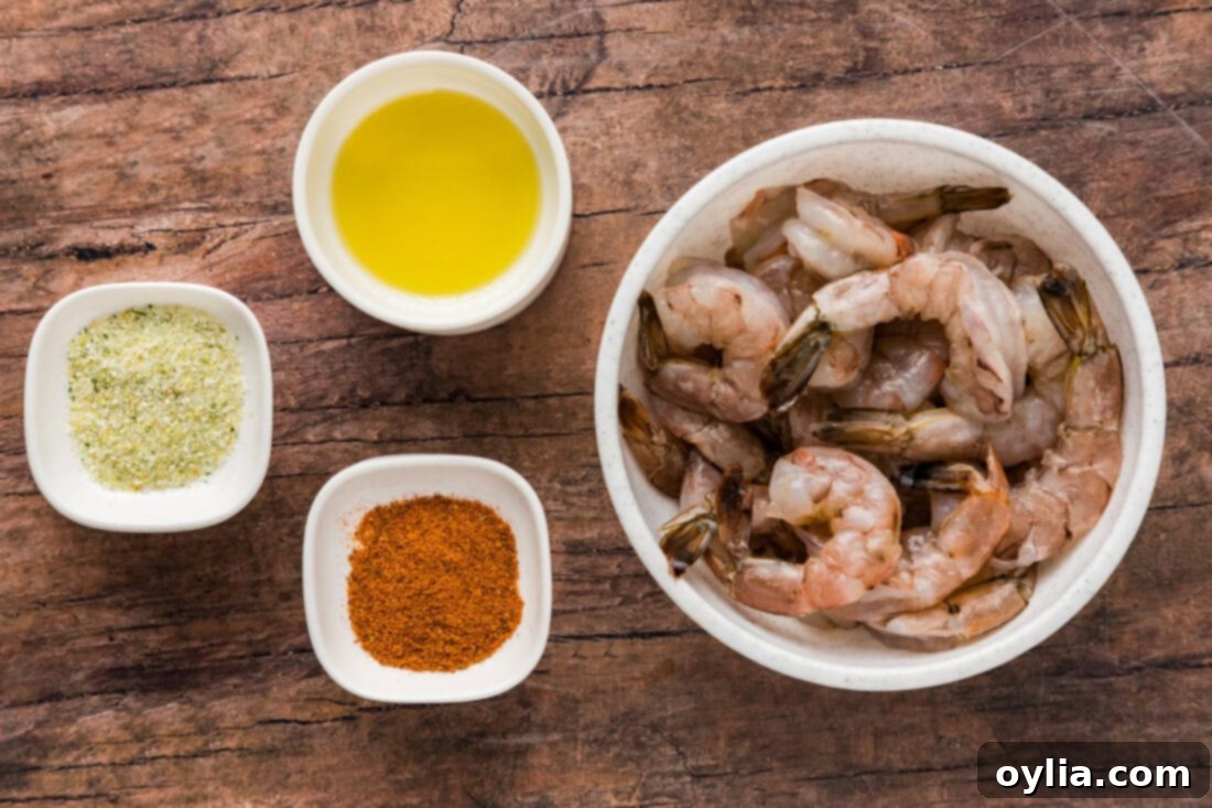 Succulent Steamed Shrimp 4 Ingredients for Steamed Shrimp including raw shrimp, Old Bay seasoning, garlic salt, and olive oil, laid out for preparation