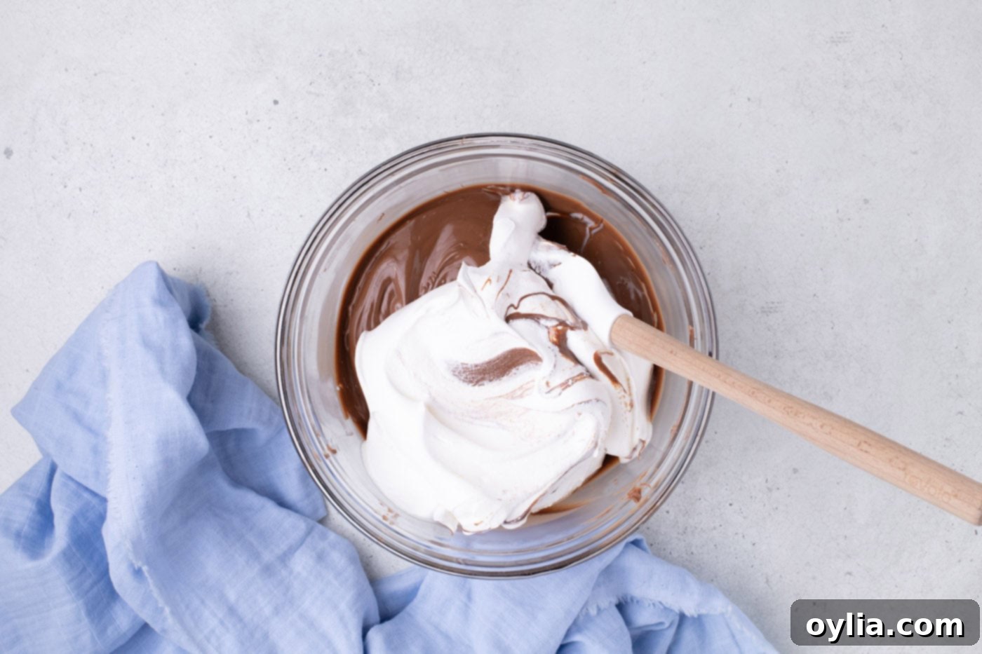 folding cool whip into melted chocolate in a bowl