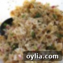 A close up photo of a vibrant tomato herb pasta salad, featuring fresh ingredients and a savory dressing.