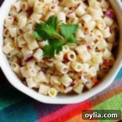 A close up overhead of three ingredient quick pasta salad in a bowl with fresh parley on top, ready to serve.