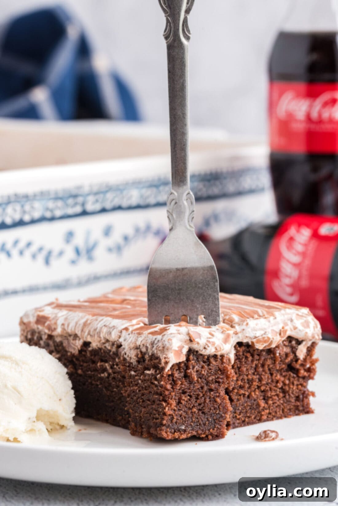 Fork standing up in a slice of Cracker Barrel Coca Cola Cake, showcasing its rich layers