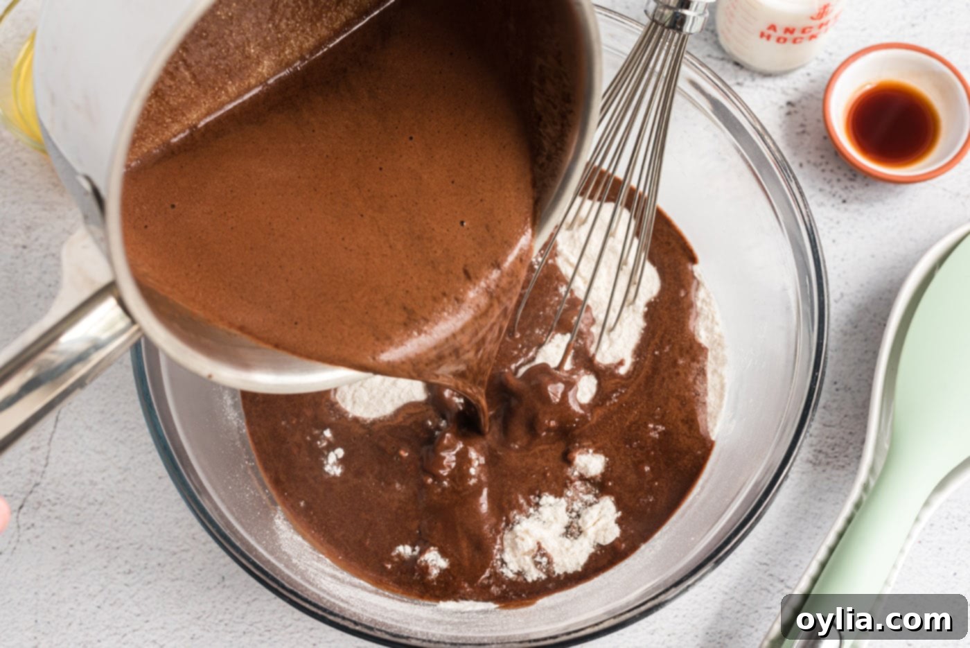 Pouring warm chocolate mixture over the flour mixture