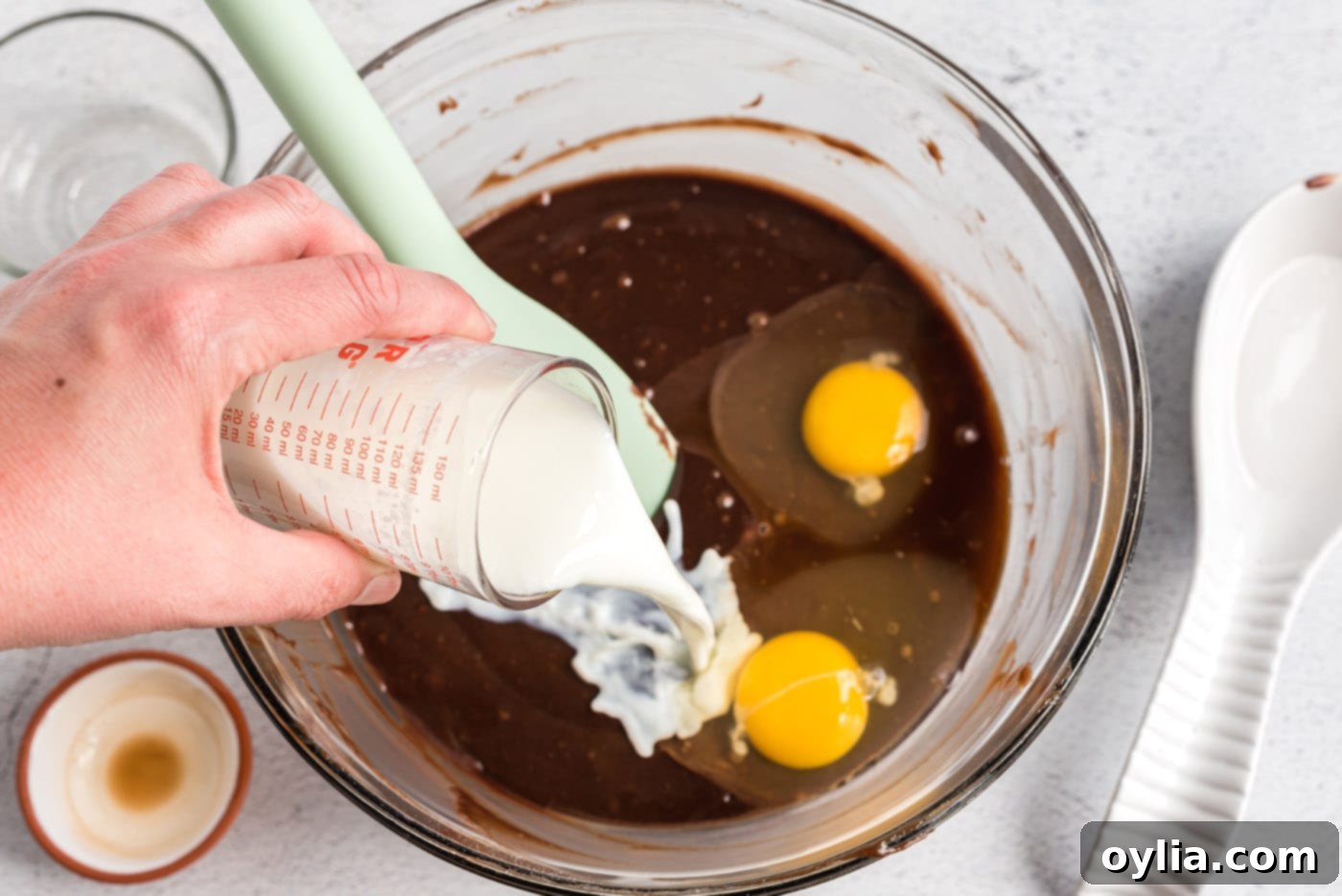 Buttermilk, eggs, and vanilla being added to the coke cake batter