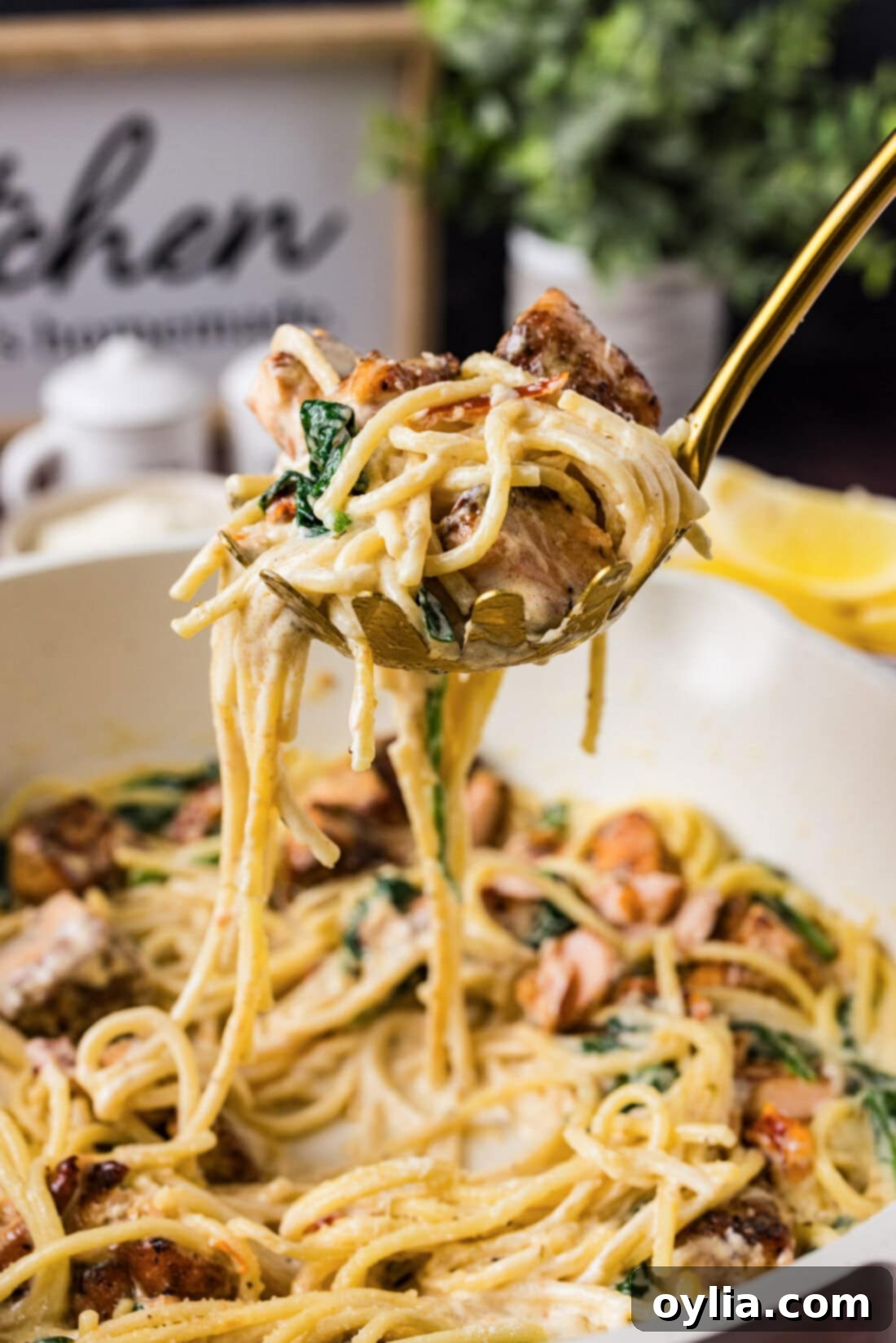 Spoonful of Salmon Pasta held above a skillet of Salmon Pasta