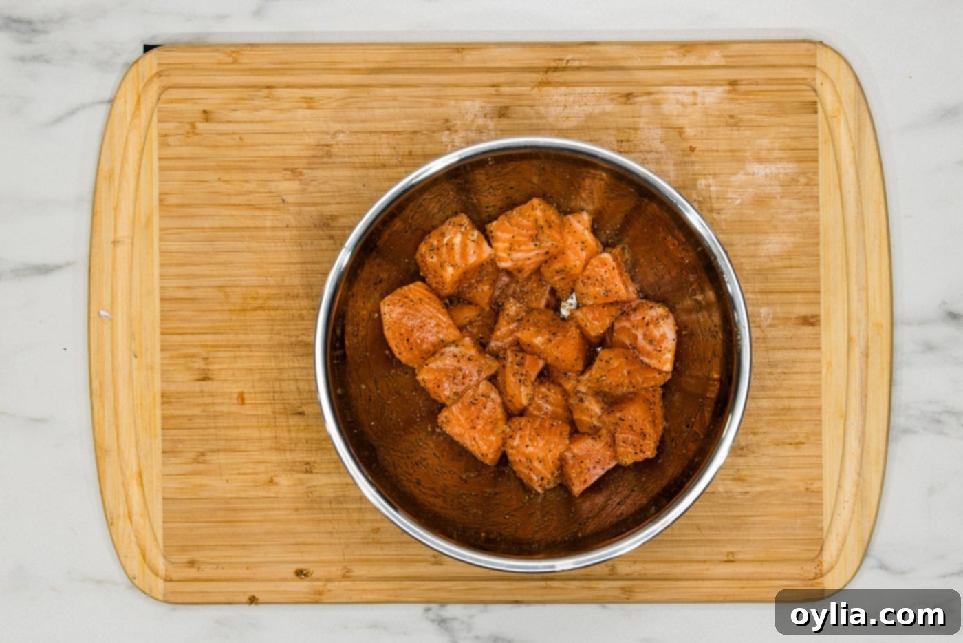 salmon cubes in a bowl with olive oil and seasonings