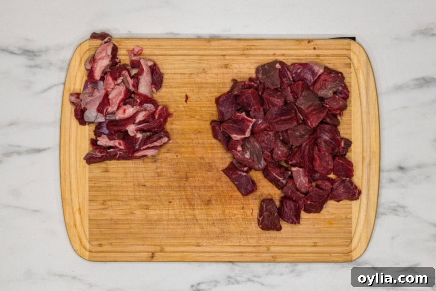 cubed steak on a cutting board with fat trimmed off