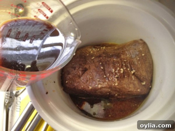 Pour the liquids over the meat in the crockpot