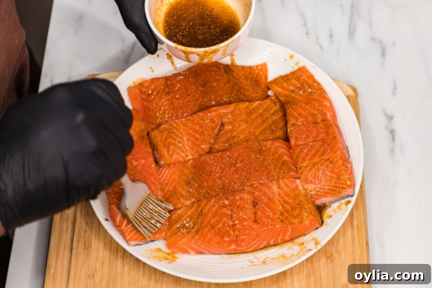 Basting salmon fillets with a mixture of olive oil and seasonings.