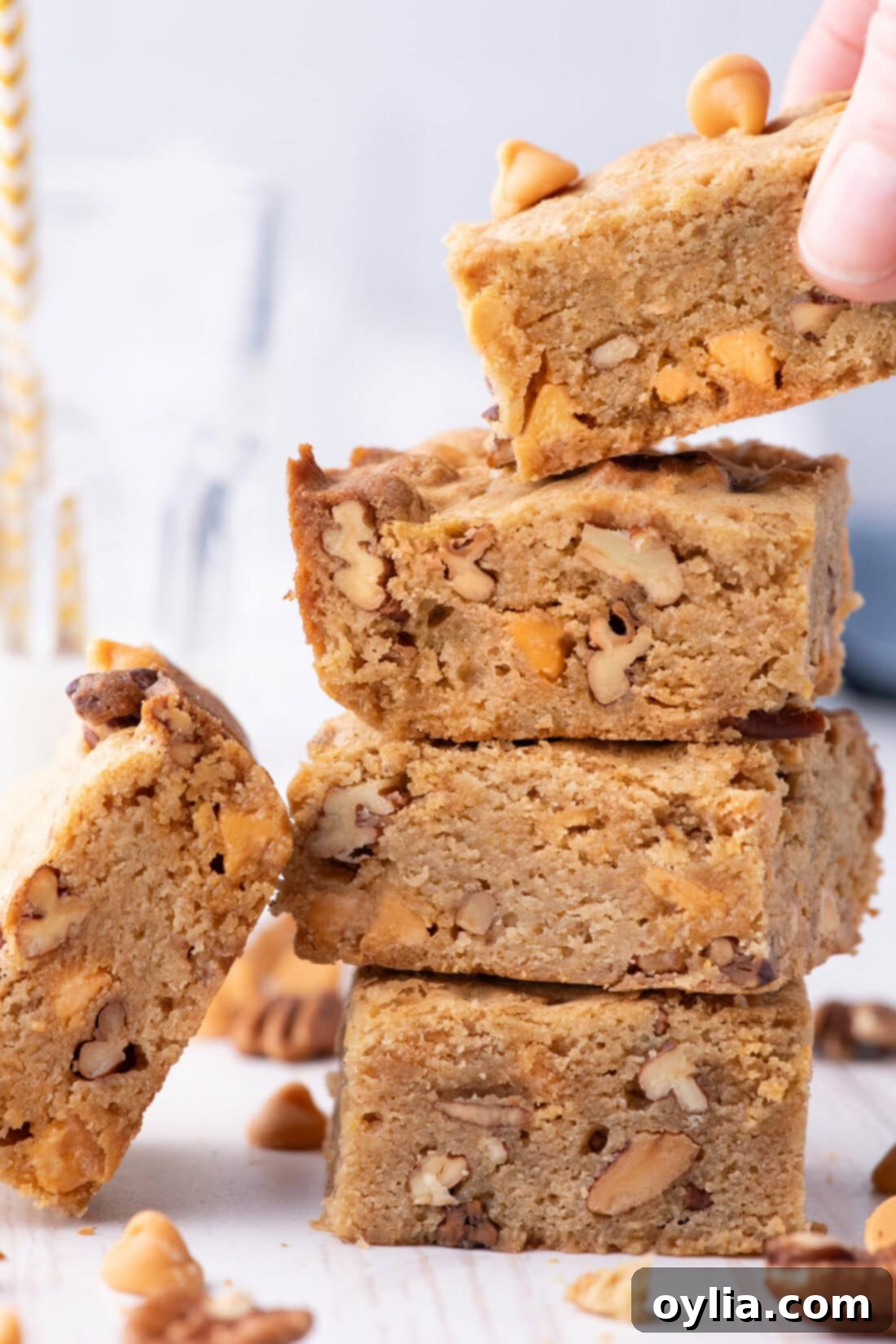 Hand grabbing a delectable Butterscotch Brownie off a stack of homemade brownies