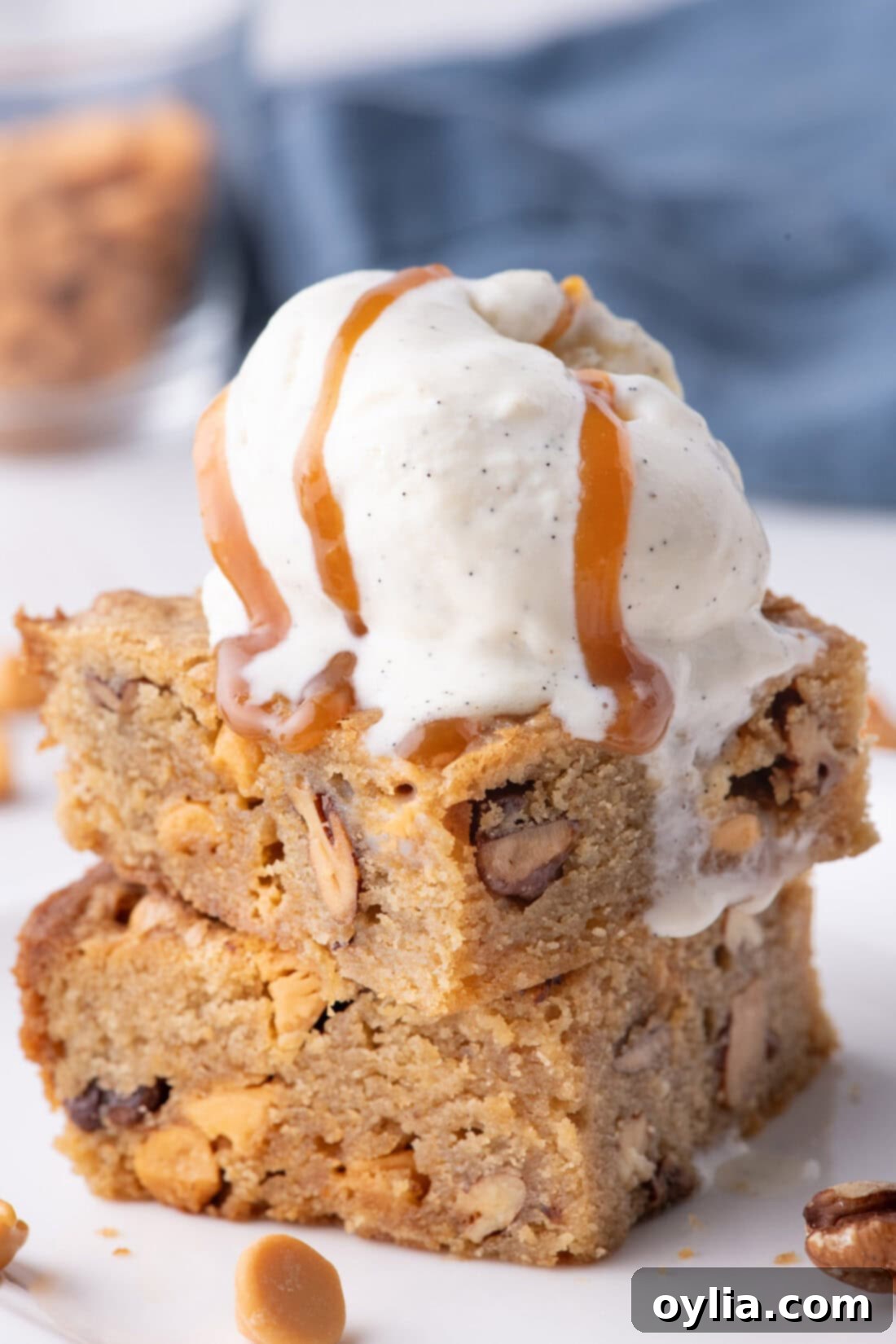 Stack of warm Butterscotch Brownies, one topped with a scoop of vanilla ice cream