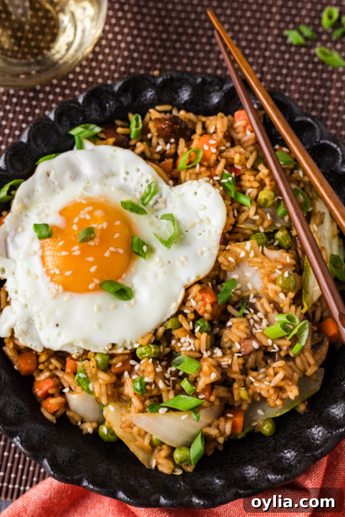 Close up photo of a bowl of Korean Fried Rice, showing fluffy rice, colorful vegetables, and a shiny sauce.