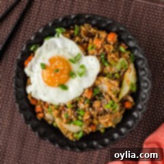 A beautiful bowl of Korean Fried Rice, garnished with a sunny-side-up egg, ready to be served.