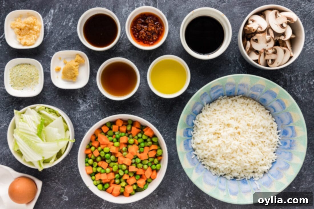 A flat lay photo showing various ingredients for Korean Fried Rice, including fresh vegetables, sauces, and rice.