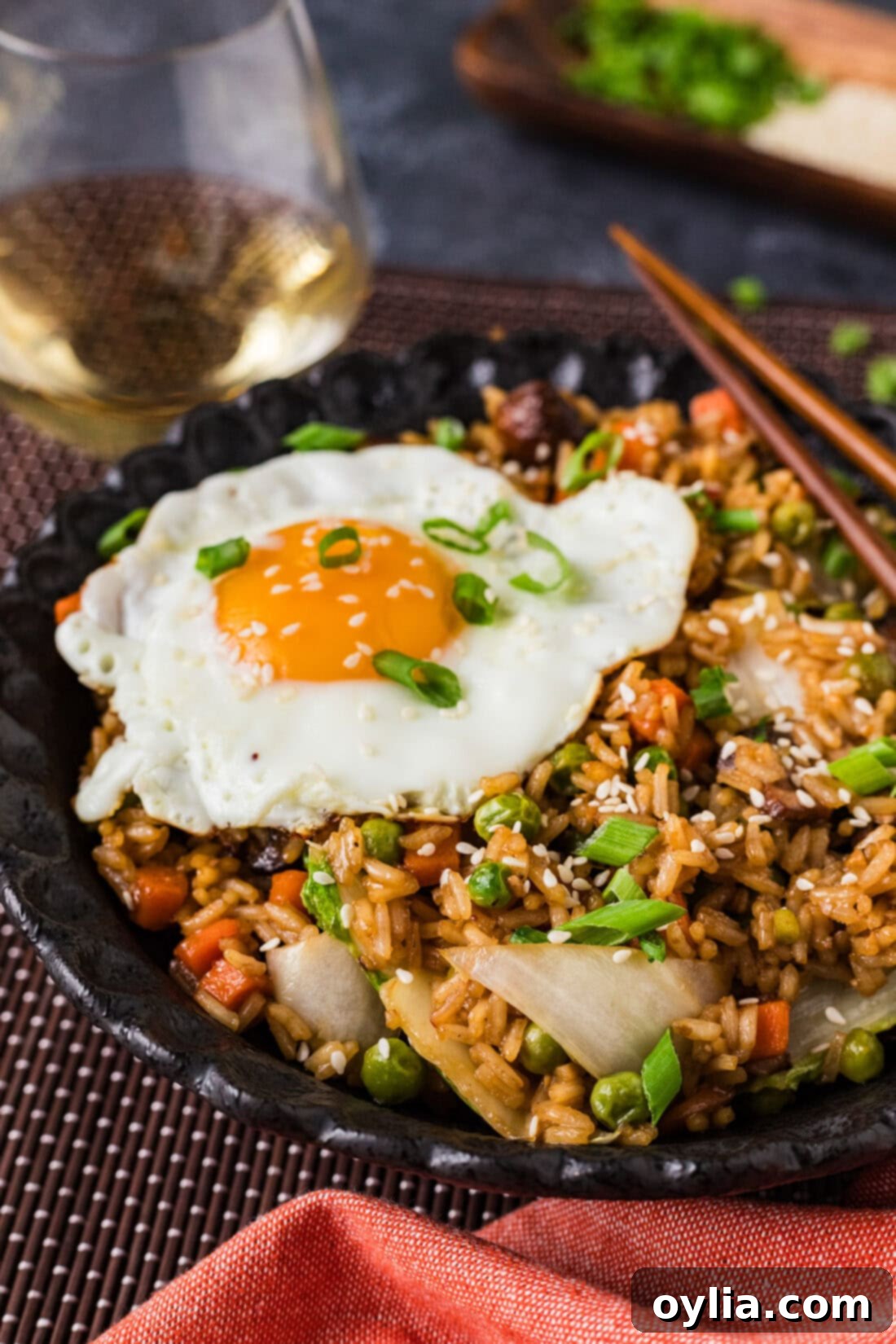 Close up side photo of a bowl of Korean Fried Rice, garnished with fresh herbs and sesame seeds.