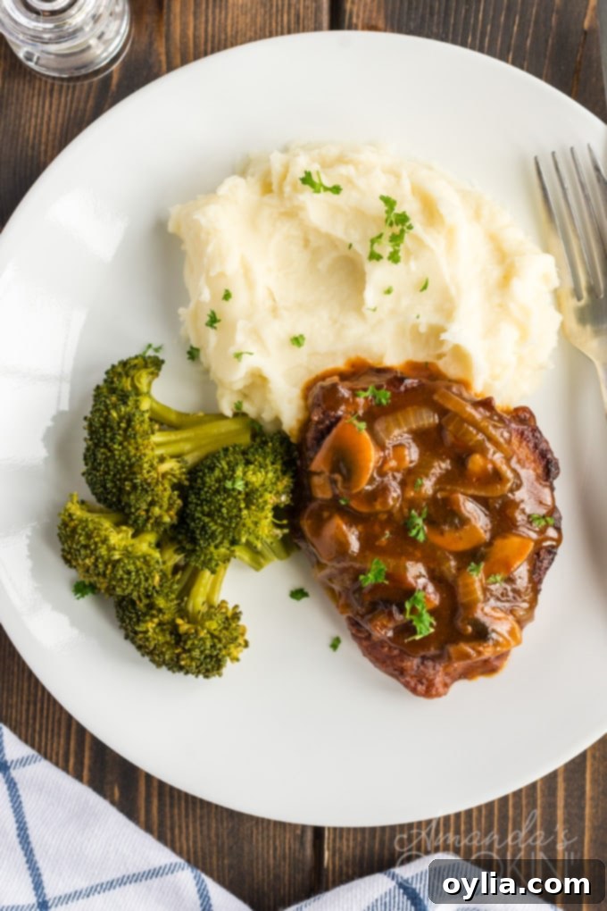 A perfectly cooked plate of Oven Swiss Steak accompanied by vibrant green broccoli.
