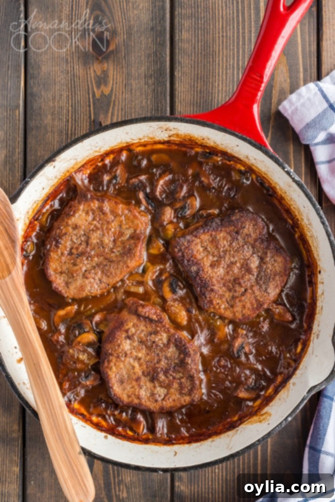 The finished, perfectly baked Swiss steak, simmering gently in a rich gravy within the skillet.